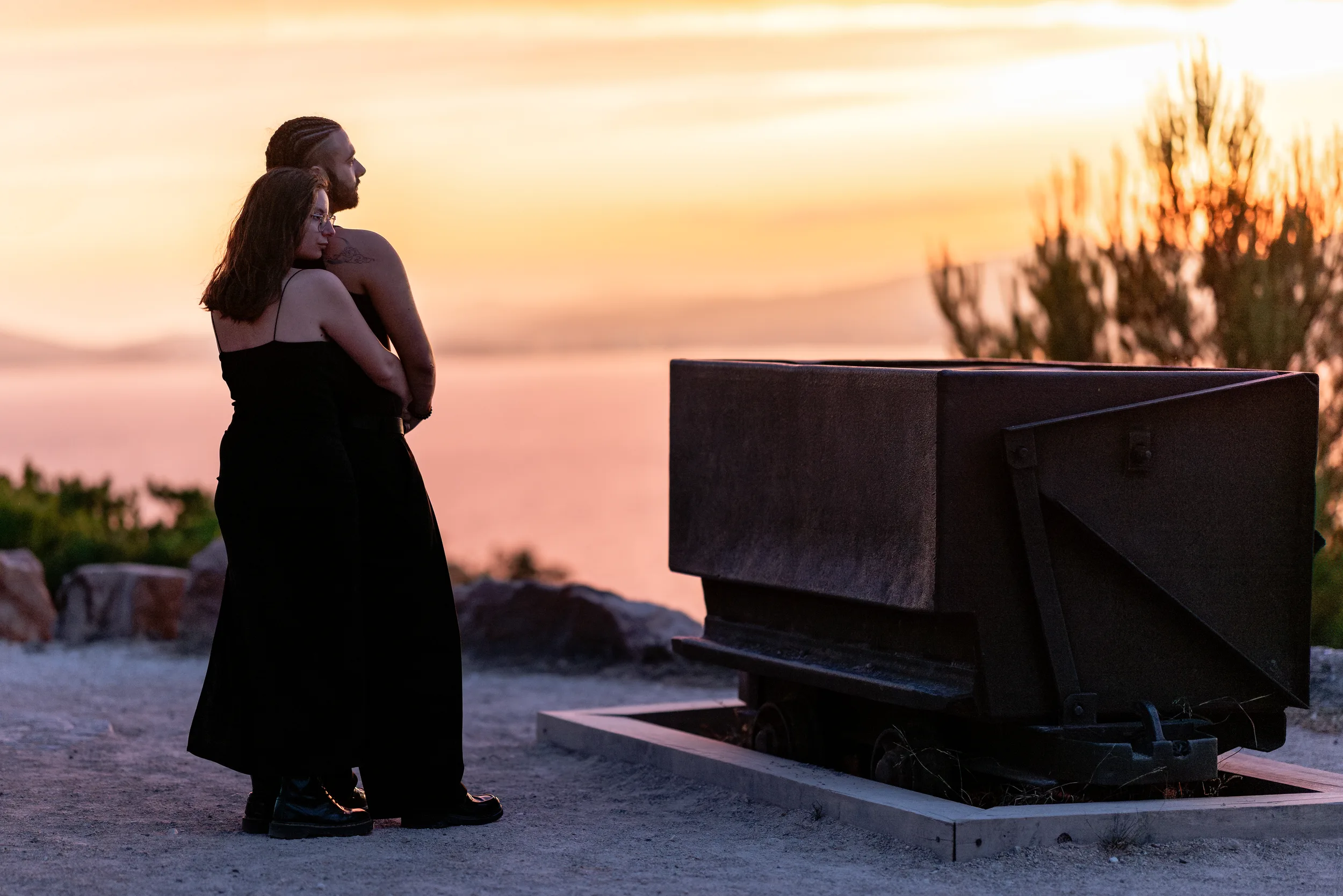 Couple devant l’ancien wagon de la Mine de Cap Garonne avec la mer au coucher du soleil
