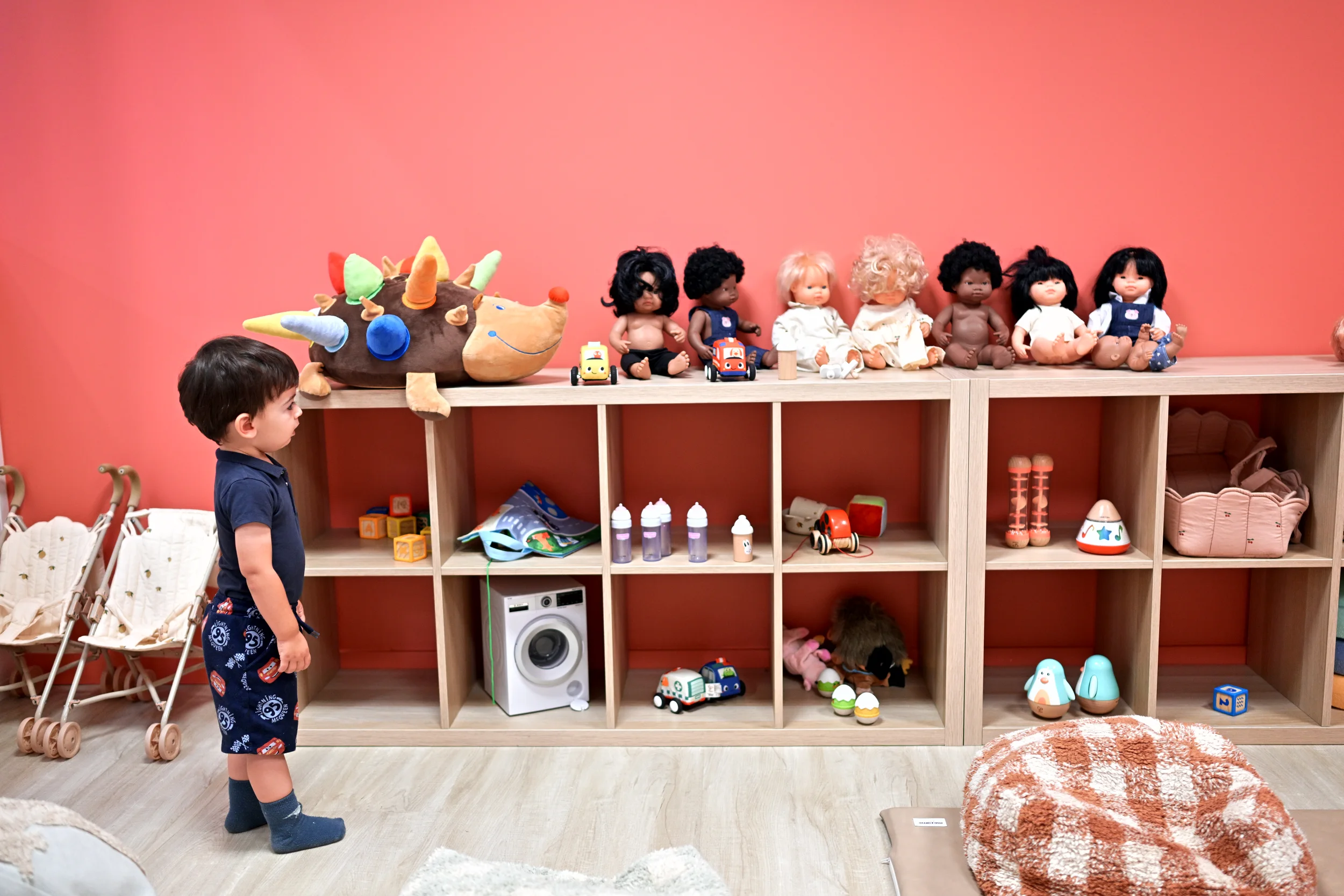 Enfant observant les poupées et les jeux dans l’espace des petits de Palomano Toulon