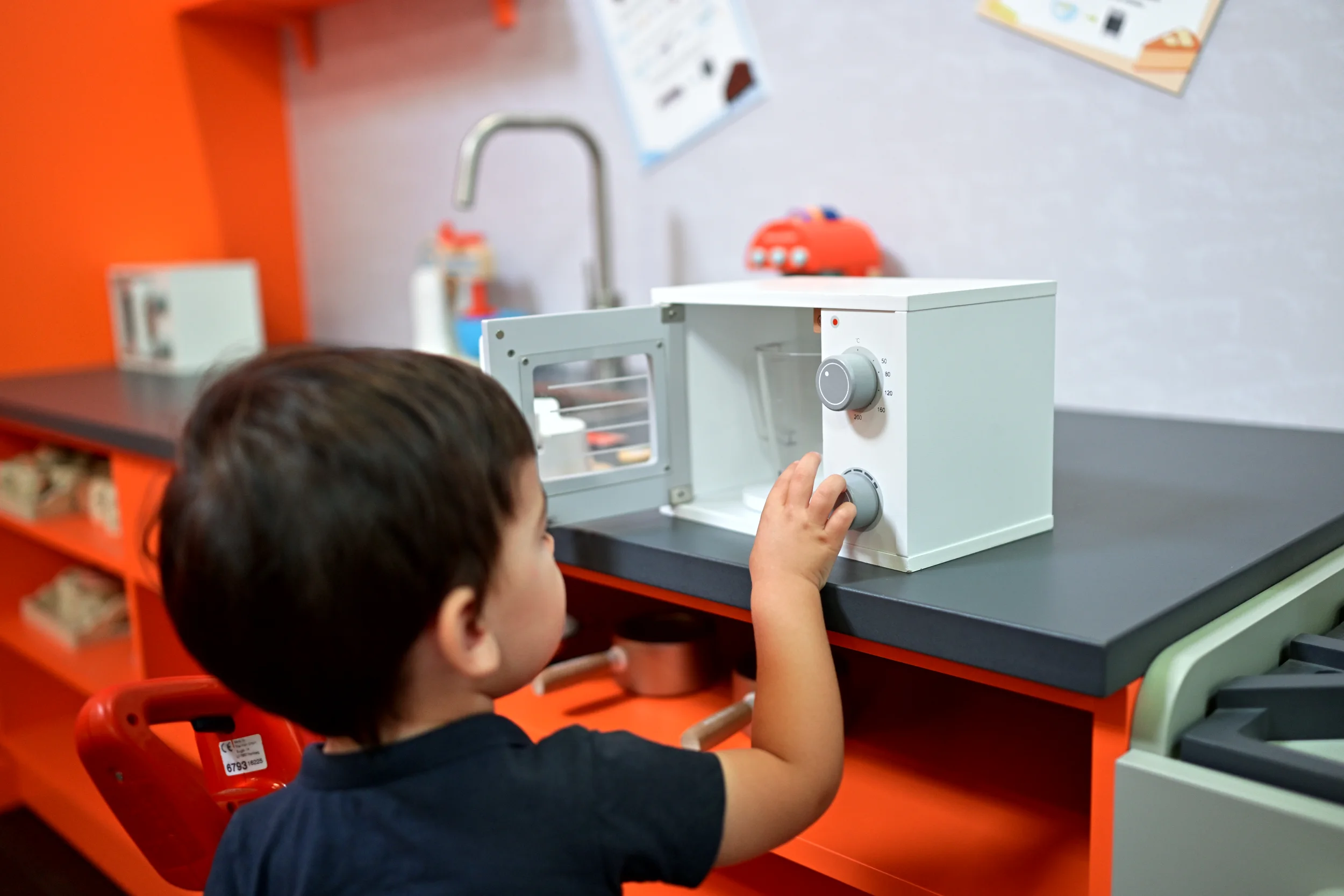 Enfant réglant un petit four dans la cuisine de Palomano Toulon