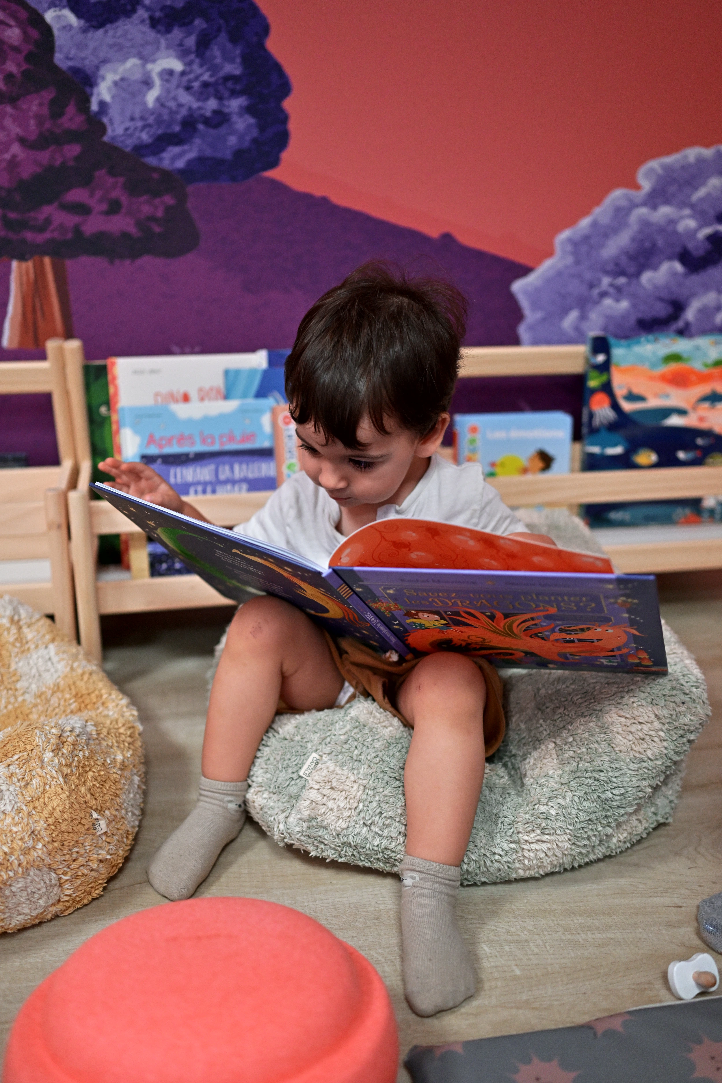 Enfant feuilletant un livre dans l’espace lecture de Palomano Toulon