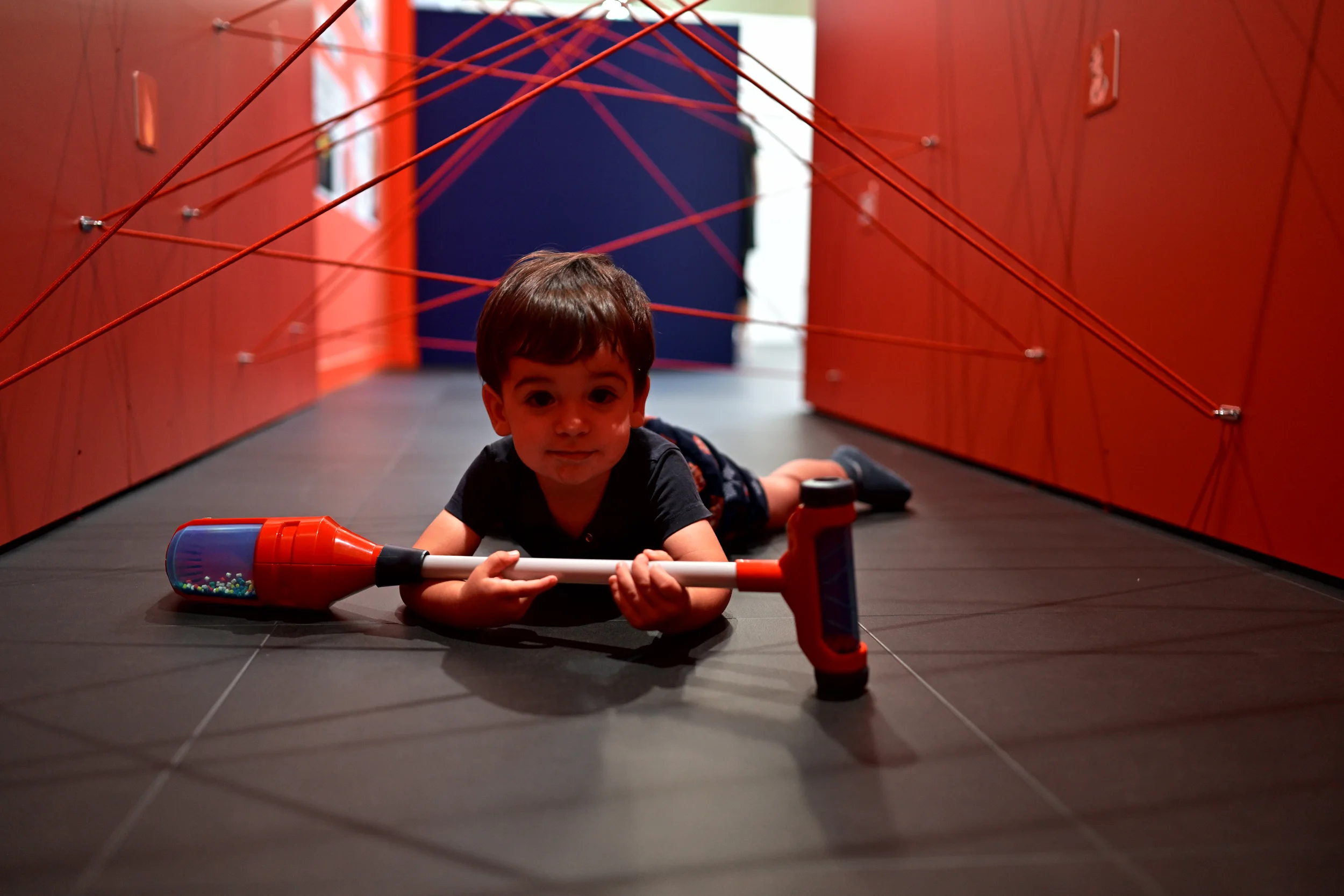 Enfant rampant sous un parcours de fils rouges à Palomano Toulon