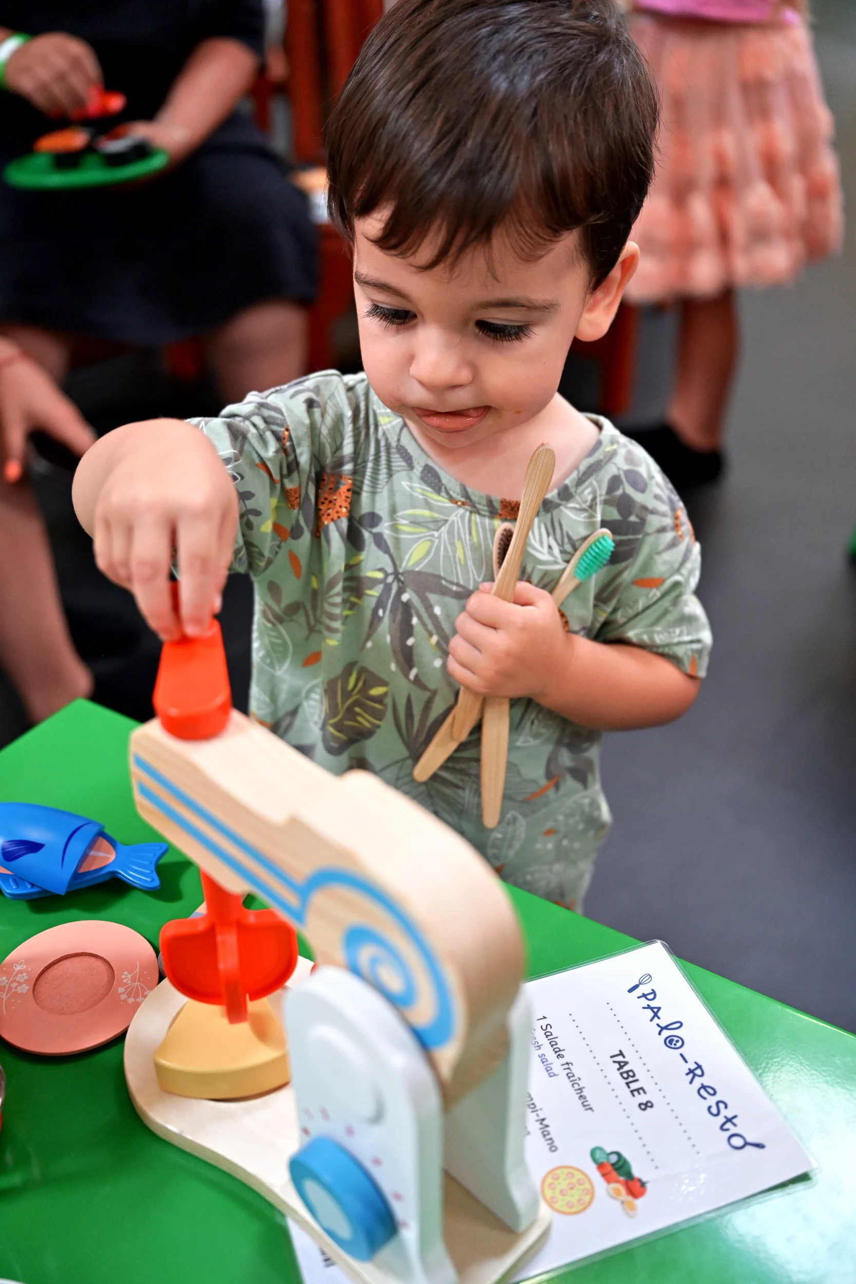 Enfant utilisant une balance dans le restaurant miniature de Palomano Toulon
