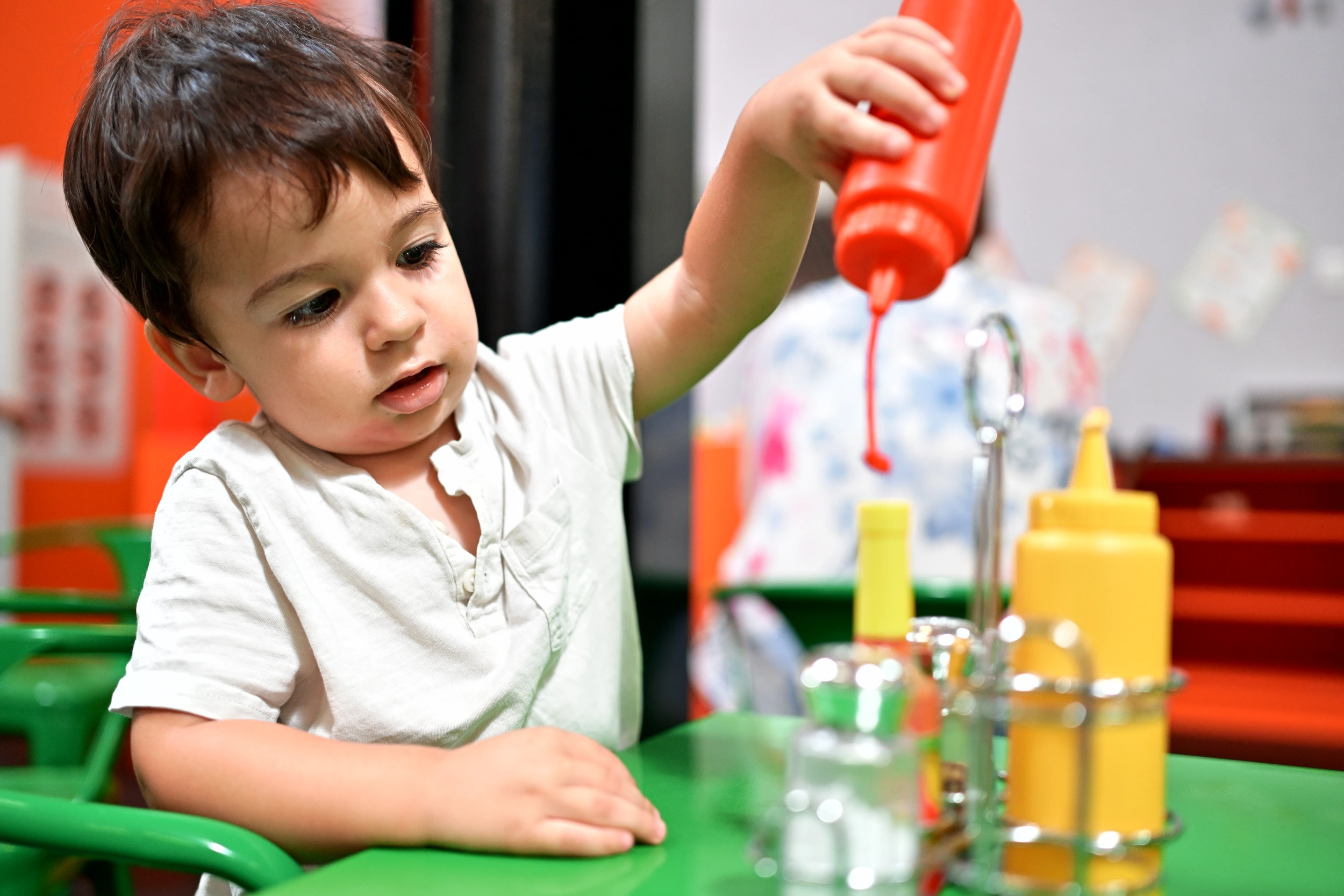 Enfant versant une sauce imaginaire au restaurant de Palomano Toulon