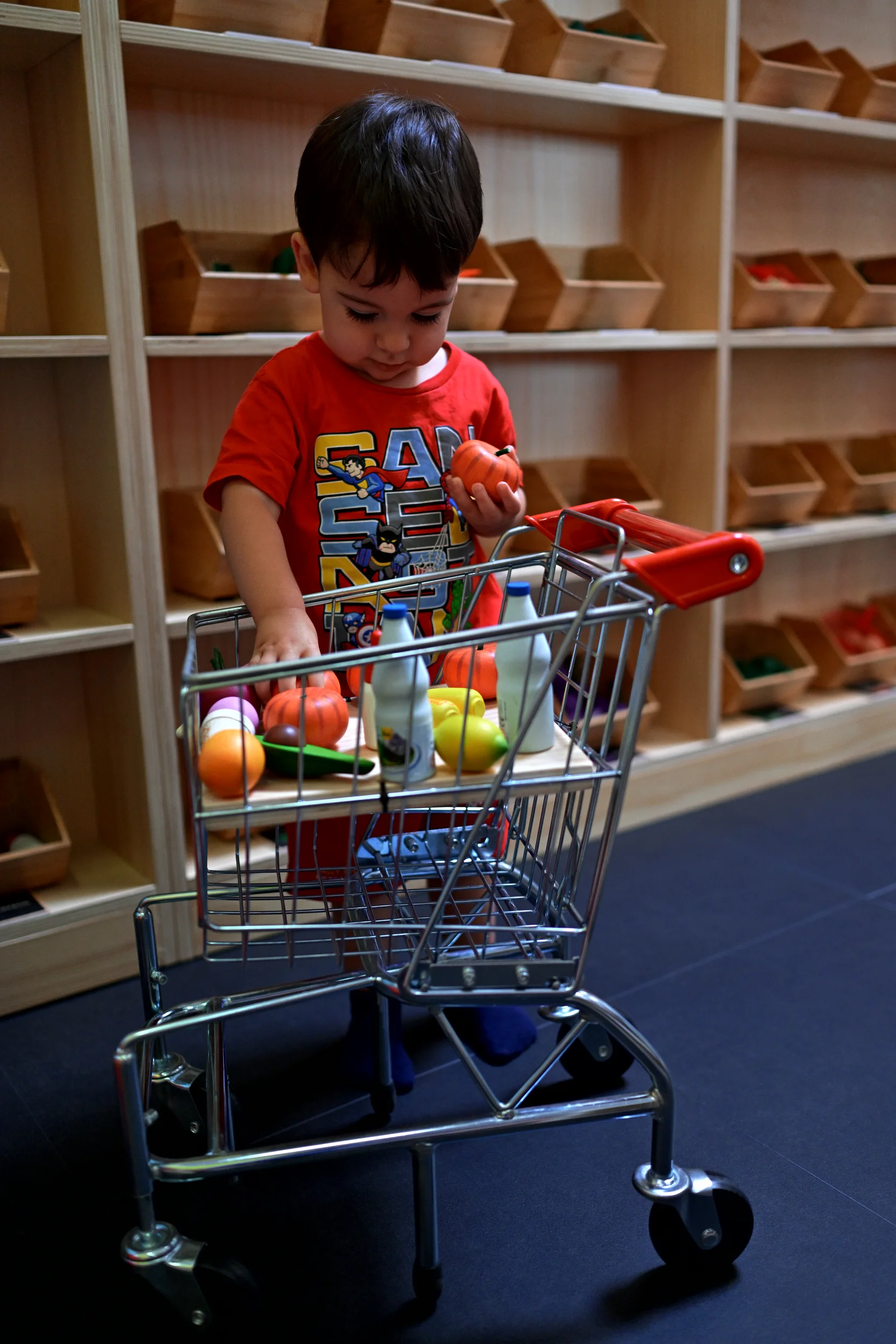 Enfant remplissant un chariot dans le supermarché miniature de Palomano Toulon