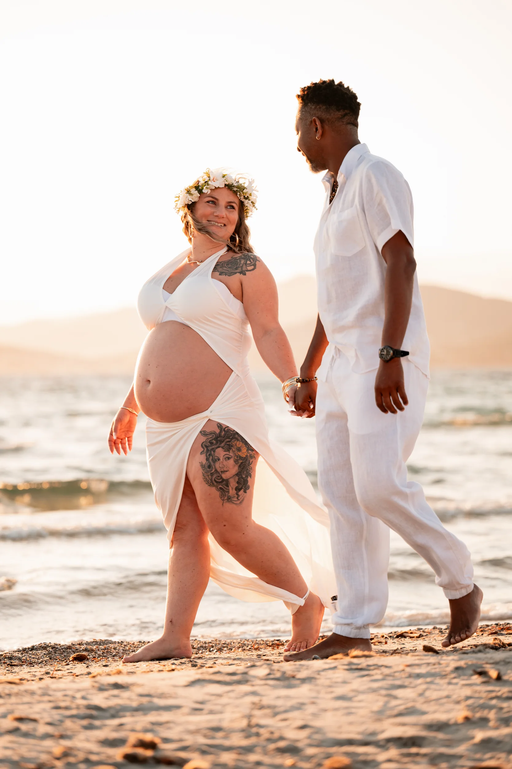 Futurs parents marchant main dans la main sur la plage de l'Almanarre à Hyères