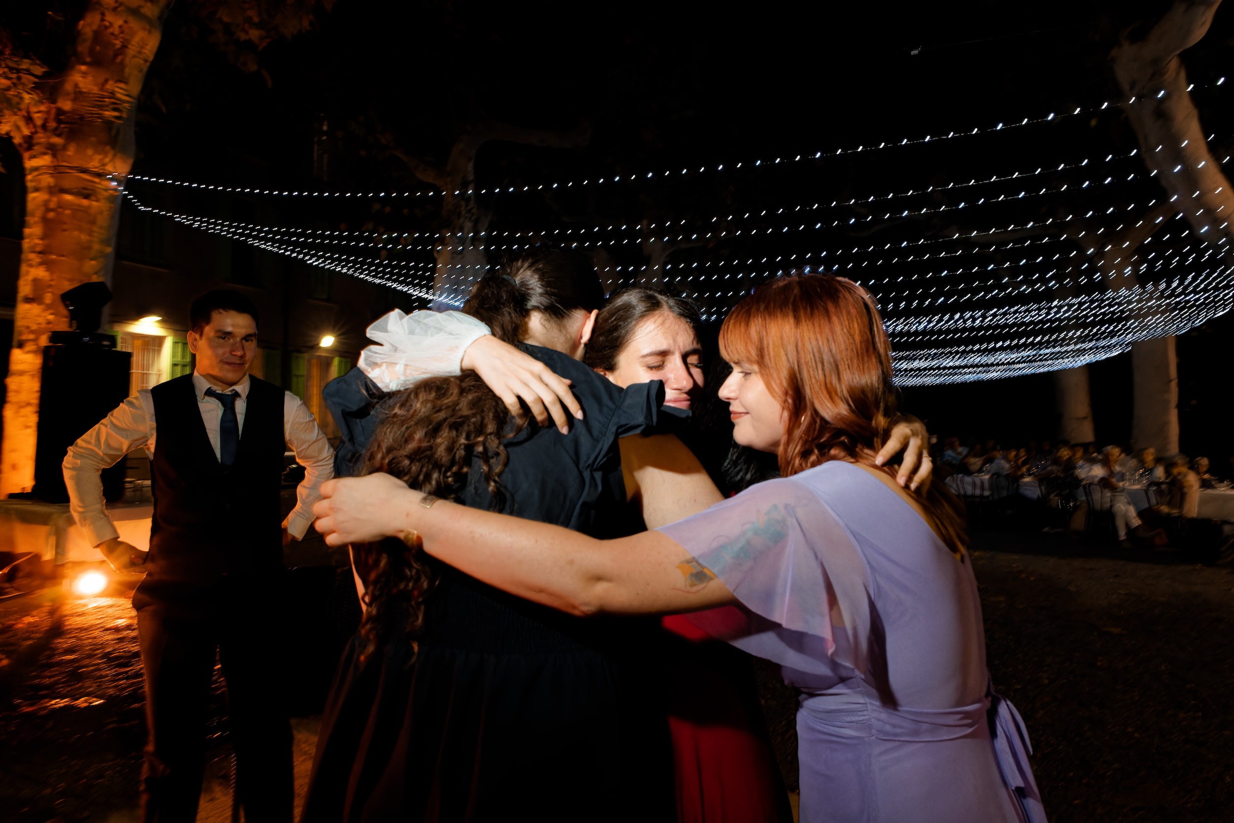 Groupe d'amies enlacées pendant la soirée de mariage