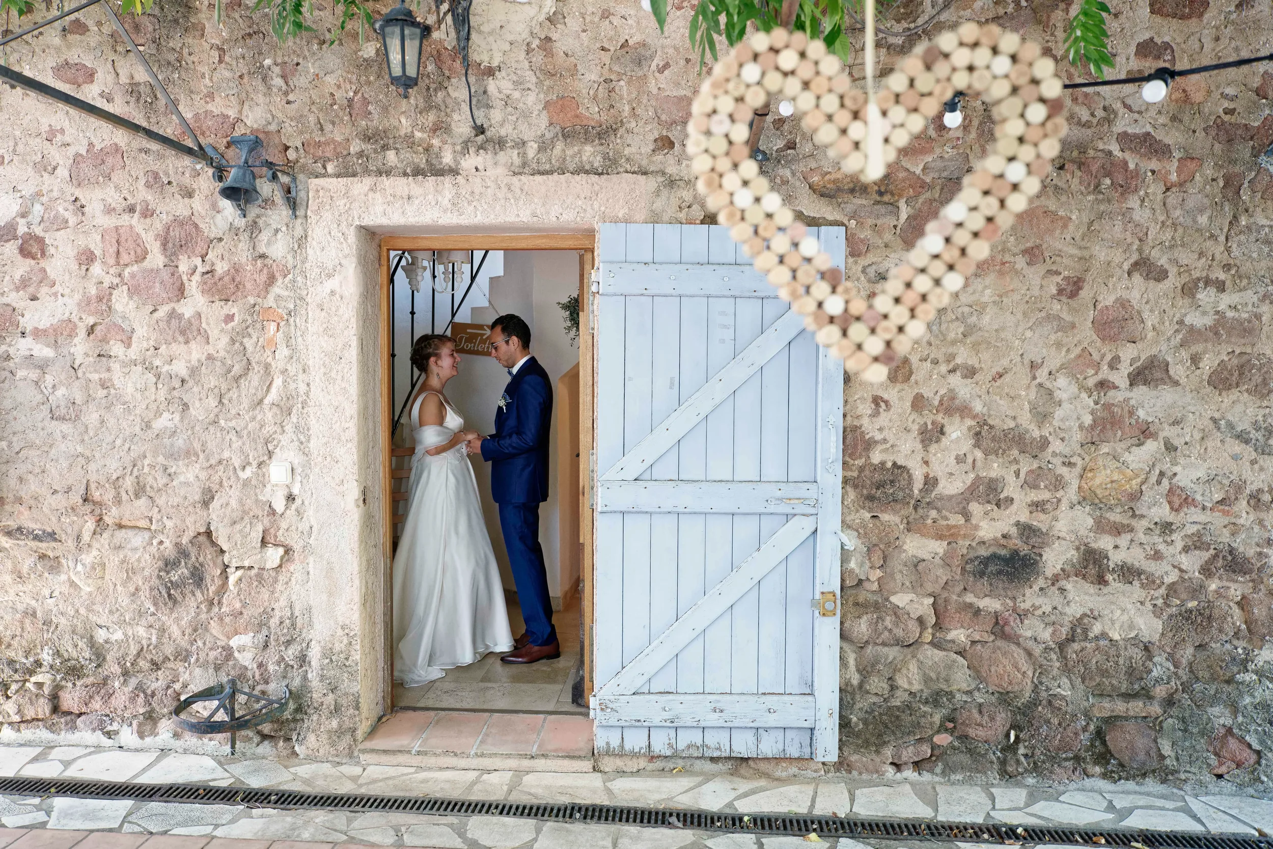 Mariés réunis dans l'encadrement d'une porte de domaine avec une décoration en coeur