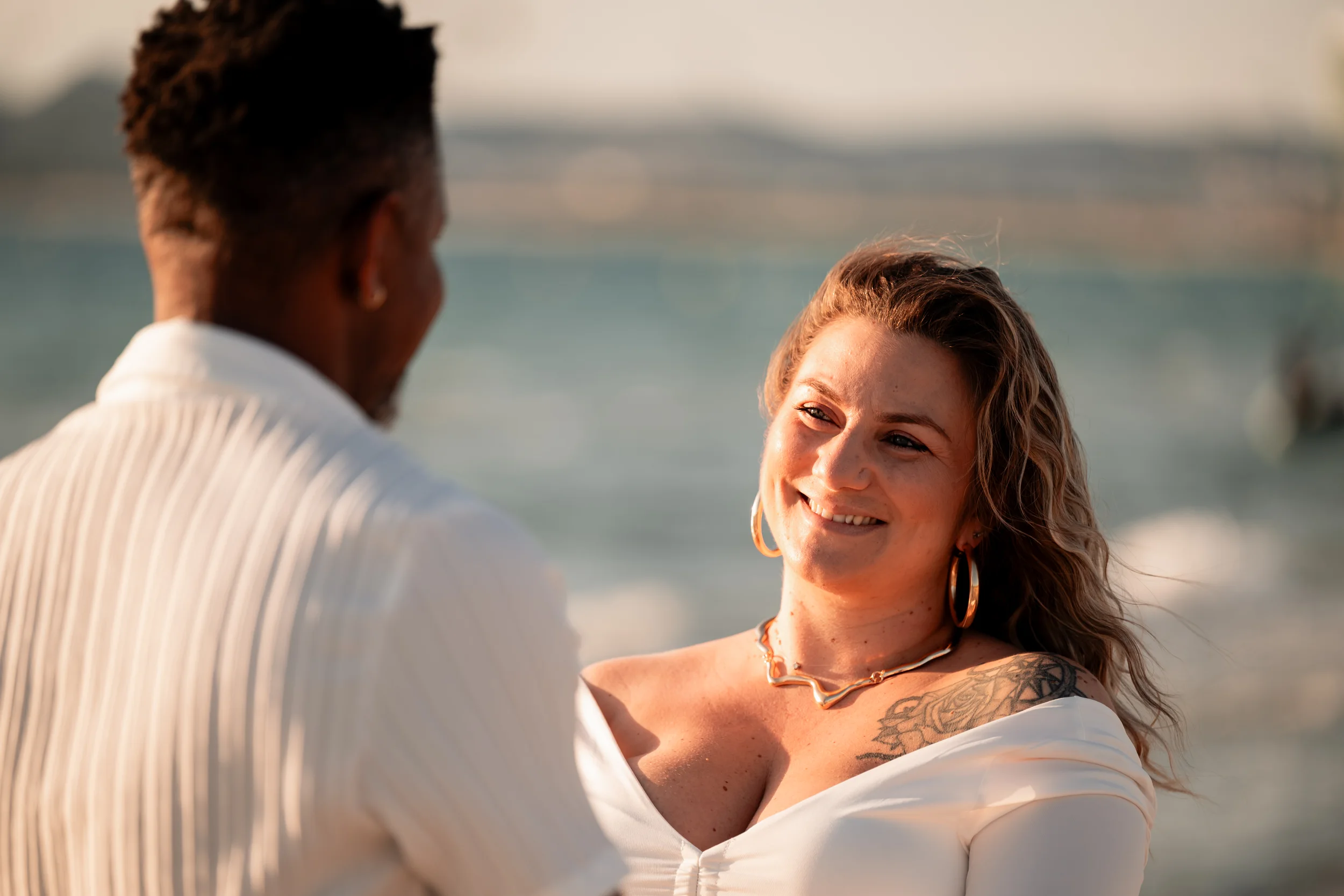 Future maman souriante face à son compagnon pendant une séance grossesse à l'Almanarre
