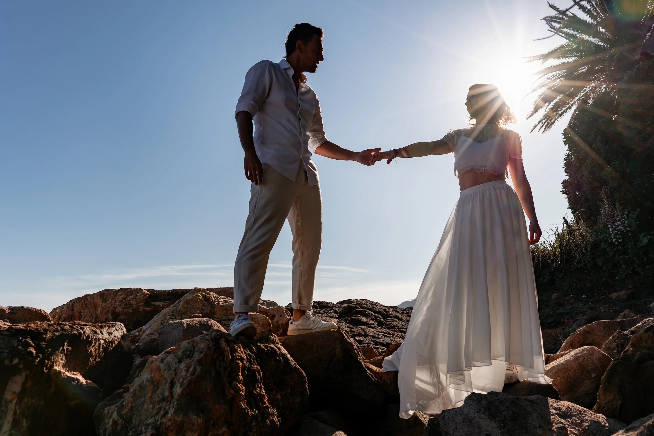 Couple enlacé en contre-jour sur les rochers