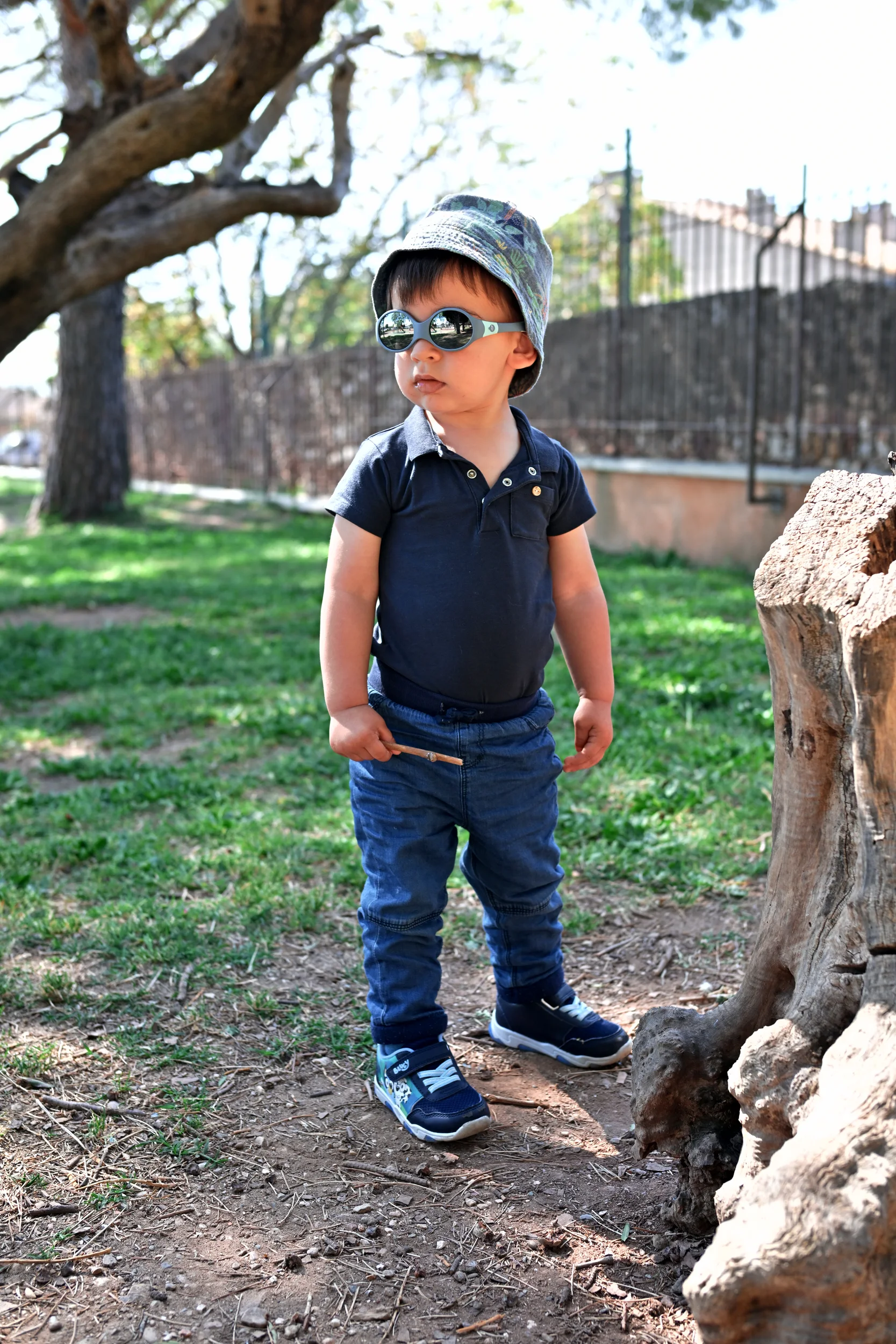 Enfant avec des lunettes de soleil pendant une séance famille au parc